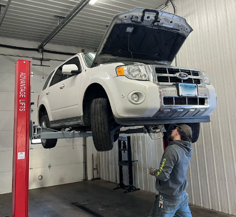 car on lift - technician working under car